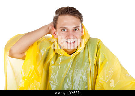 Picture of a caucasian young man wearing a yellow raincoat, posing on isolated background Stock Photo