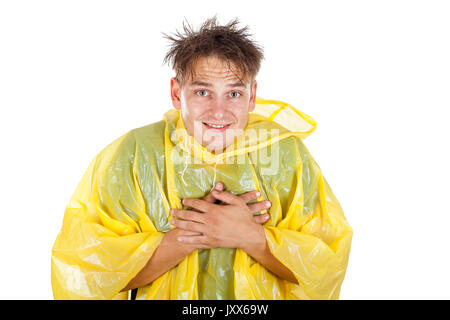 Picture of a caucasian young man wearing a yellow raincoat, posing on isolated background Stock Photo