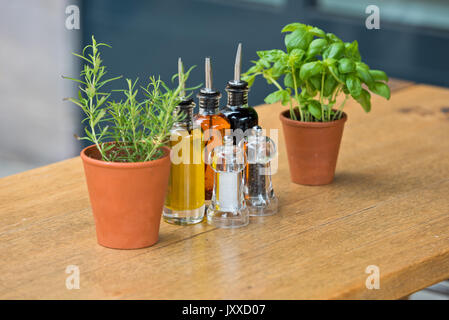 Balsamic vinegar and oil bottles and condiments on the table in an outdoor cafe Stock Photo