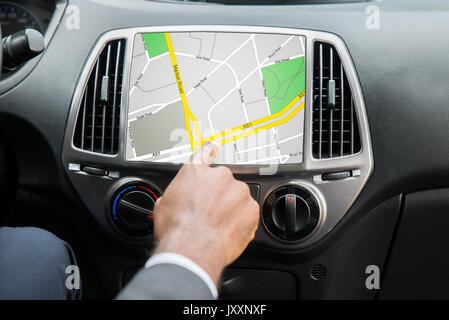 Close-up Of Person's Hand Using GPS Navigation System In Car Stock Photo
