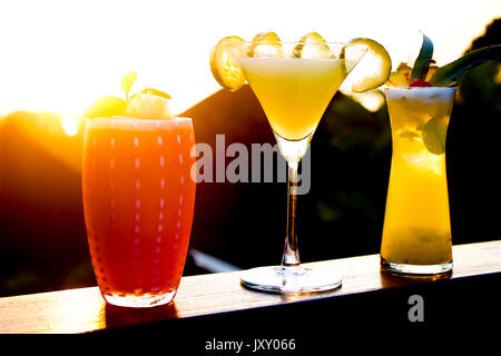 Four fresh fruit cocktails drinks at sunset in a luxury resort in Phuket Island, Thailand Stock Photo