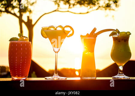 Four fresh fruit cocktails drinks at sunset in a luxury resort in Phuket Island, Thailand Stock Photo