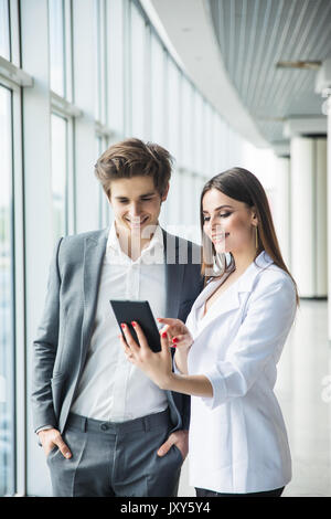 Cheerful photo editors working together on tablet pc in office Stock Photo