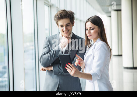 Cheerful photo editors working together on tablet pc in office Stock Photo