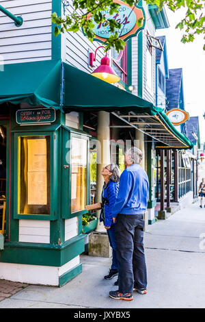 Bar Harbor, USA - June 8, 2017: Couple standing on sidewalk in downtown village in summer looking at restaurant menu Stock Photo