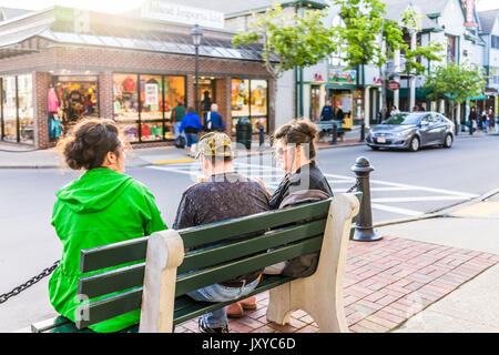 Bar Harbor, USA - June 8, 2017: People on benches in Maine downtown village in summer evening eating ice cream Stock Photo