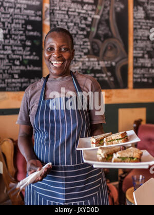 Waitress with sandwiches at Monocle & Mermaid in Simon's Town, Cape Town. Stock Photo