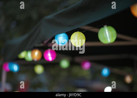 Many Colorful Small Paper Lanterns on a Tent at Night Stock Photo
