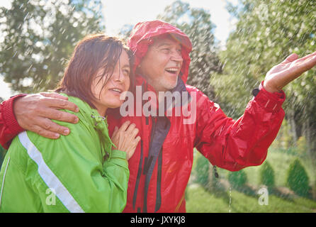 Senior couple embracing in rain Stock Photo