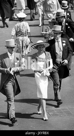 Diana, Princess of Wales, wearing a silk dress with blue and white striped shawl collar teamed with a large sombrero while attending Royal Ascot. Behind the Princess is Sergeant Allan Peters. Stock Photo