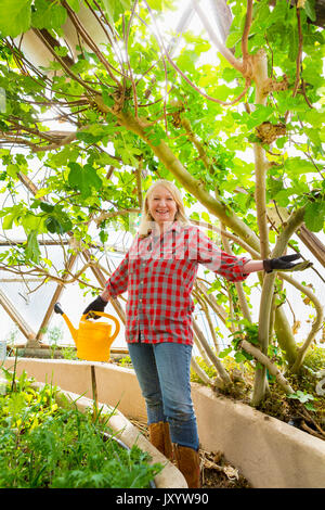 Caucasian woman posing in greenhouse Stock Photo