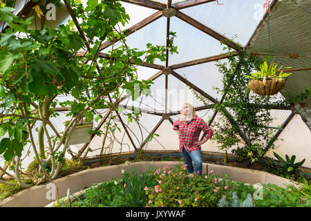 Caucasian woman posing in greenhouse Stock Photo