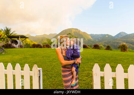 Caucasian mother carrying and kissing son Stock Photo