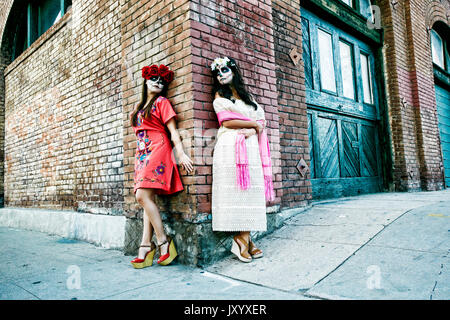 Women on sidewalk corner wearing skull face paint Stock Photo