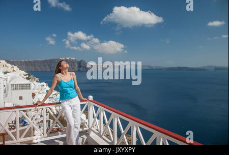 Caucasian woman leaning on balcony railing overlooking ocean Stock Photo