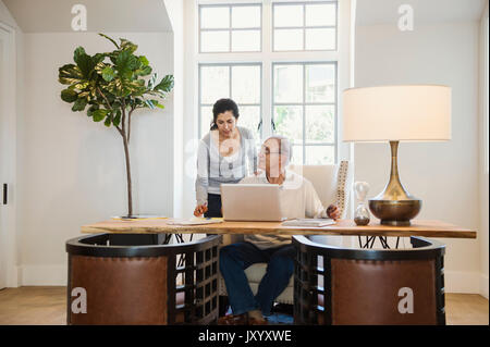 Older couple using laptop in home office Stock Photo