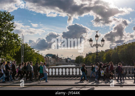 People cross O'Connell Bridge across the River Liffey in the Irish capital city, Dublin Stock Photo
