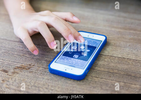 Bangkok, Thailand - 12 August 2017 - Female hand select apps on Apple iPhone in Bangkok, Thailand on August 12, 2017 Stock Photo