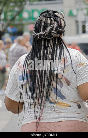 A view from the rear of a woman with three colors of hair extensions beautifuly braided. In lower Manhattan, New York City. Stock Photo