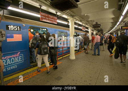 Commuters board the shuttle train from Times Square to Grand Central Station shuttle in Midtown Manhattan, New York City. Stock Photo