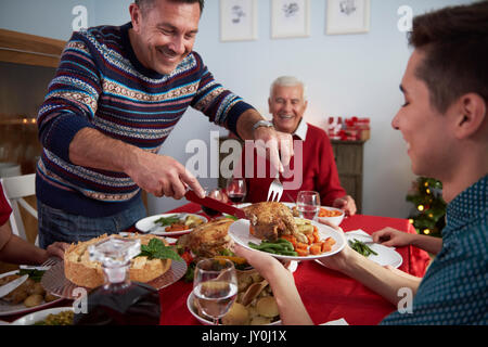 Father serves dinner at Christmas Eve Stock Photo