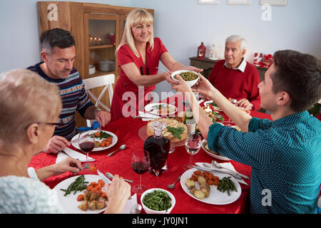 Son helping mother at the Christmas dinner Stock Photo