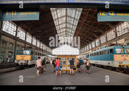 BUDAPEST, HUNGARY - AUGUST 11, 2017: main platform of the Budapest Nyugati palyaudvar train station with people buying train tickets on a vending mach Stock Photo