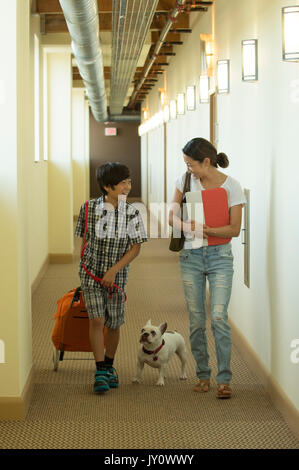 Asian mother and son in corridor with dog Stock Photo