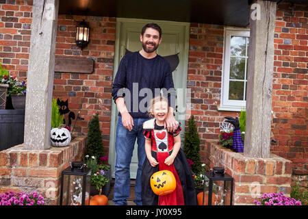 Father And Daughter Outside House Trick Or Treating Stock Photo