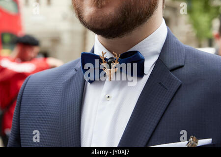 Man in street wearing blue bow tie and broach, close up, crop Stock Photo