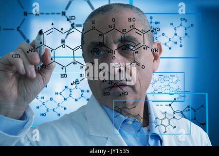 Hispanic scientist writing formula on glass wall Stock Photo