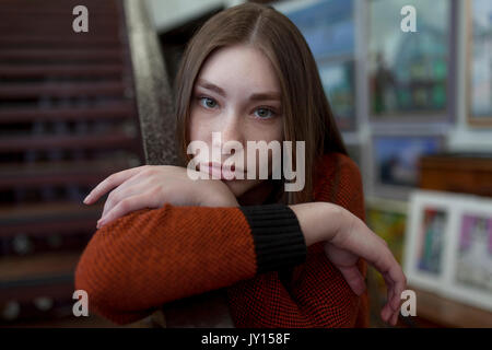 Caucasian woman leaning on staircase railing Stock Photo