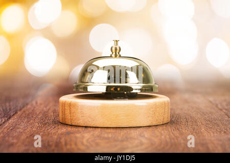 Close-up Of Service Bell On Wooden Desk Stock Photo