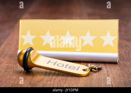 Hotel Key Is Placed Near Five Star Shape Card On Wooden Desk In Hotel Stock Photo