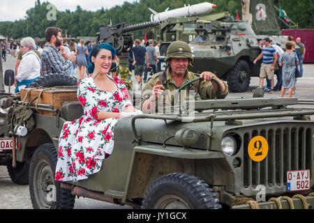 Reenactors dressed as WW2 US soldier and woman in 1940s dress posing in WWII military Willys MB jeep during World War Two militaria fair Stock Photo