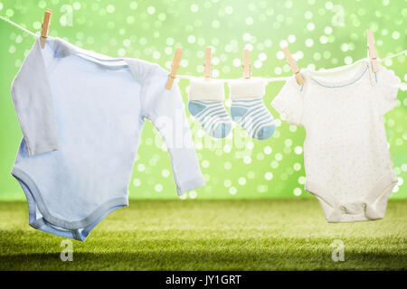 Baby Cloths And Baby Sock Hanging On Rope Using Wooden Clip Stock Photo