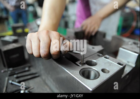 Worker's hand screwing while working with press form Stock Photo
