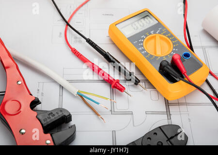 High Angle View Of Digital Multimeter On Blueprint With Red And Black Wire Stock Photo