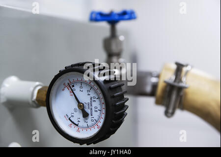 Closeup of pressure vacuum gauge and blue valve Stock Photo