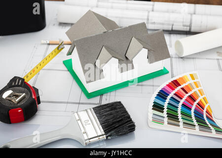 High Angle View Of House Model With Blueprint And Other Materials On Office Desk Stock Photo