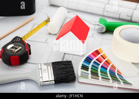High Angle View Of House Model With Blueprint And Other Materials On Office Desk Stock Photo
