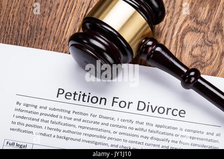 Wooden Gavel On Petition For Divorce Paper At Wooden Desk In Courtroom Stock Photo