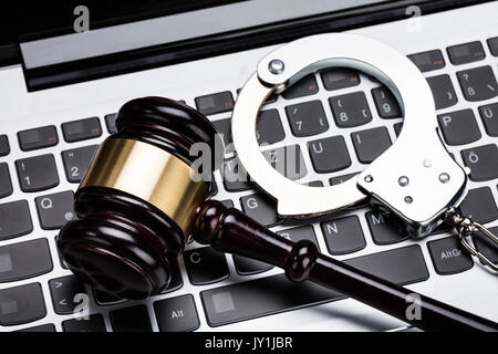 High Angle View Of Judge Gavel And Handcuff On Laptop Keyboard Stock Photo