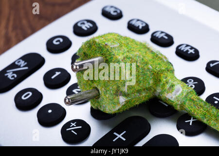 Close-up Of Green Eco Electric Cable On Calculator Button Stock Photo