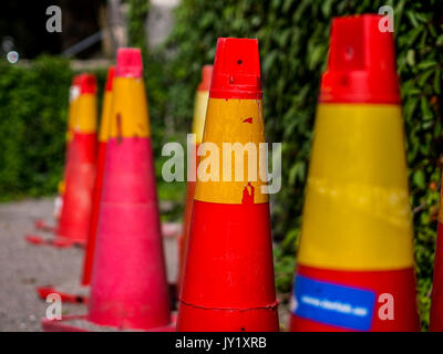 Traffic cones by a leaf covered stone wall Stock Photo