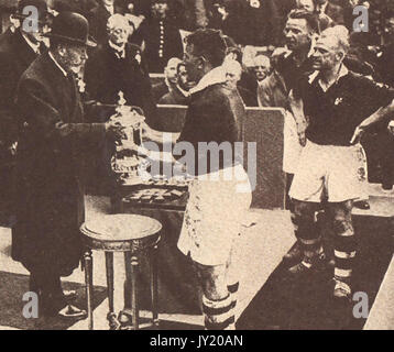 1934 - King George V of England presenting the winners cup  at the AFC final at Wembley, London to team Captain, Sam Cowan of the Manchester United team who beat Portsmouth 2-1. Stock Photo