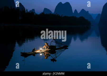Cormorant fisherman pre-dawn preparing to fish, Li River, Chinaq Stock Photo