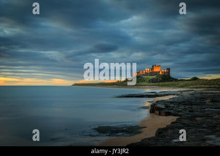 Bamburgh castle sunrise on the Northumberland coastline Stock Photo