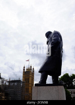 The statue of Winston Churchill in Parliament Square, London, looking over the Houses of Parliament as Big Ben goes silent. Stock Photo