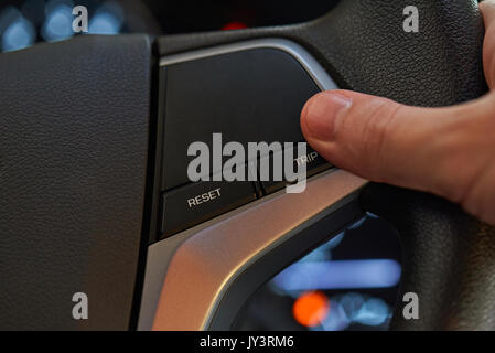 Finger press trip button on car wheel close-up Stock Photo